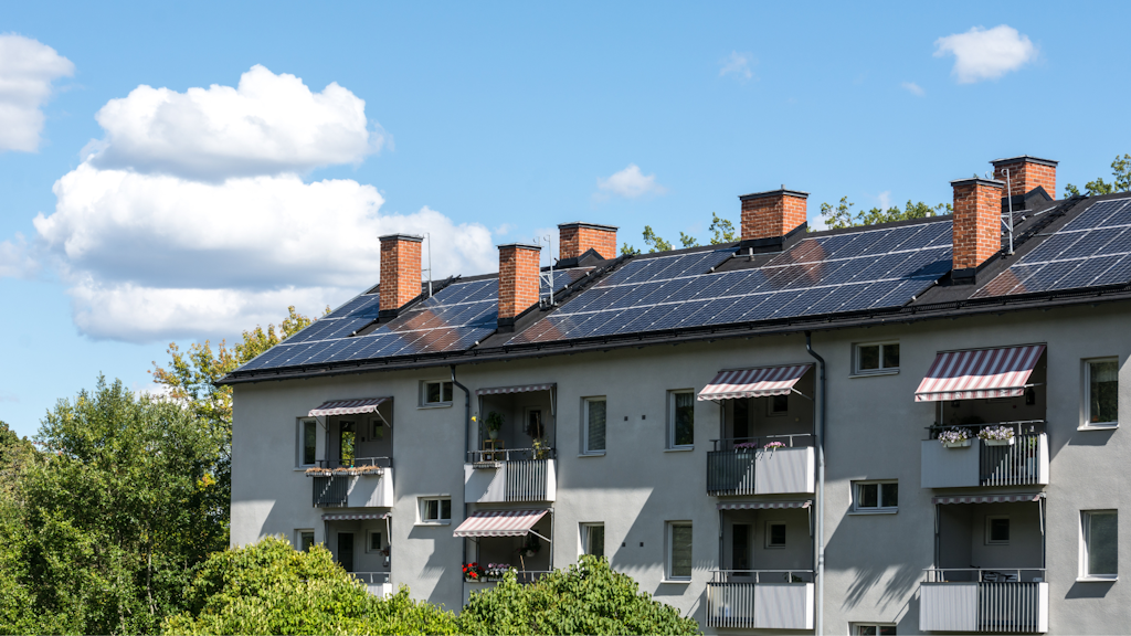 Flerfamiljshus med flera fönster vilket visualiserar en bostadsrättsförening som kan minska sitt energibehov genom både enkla åtgärder och större investeringar