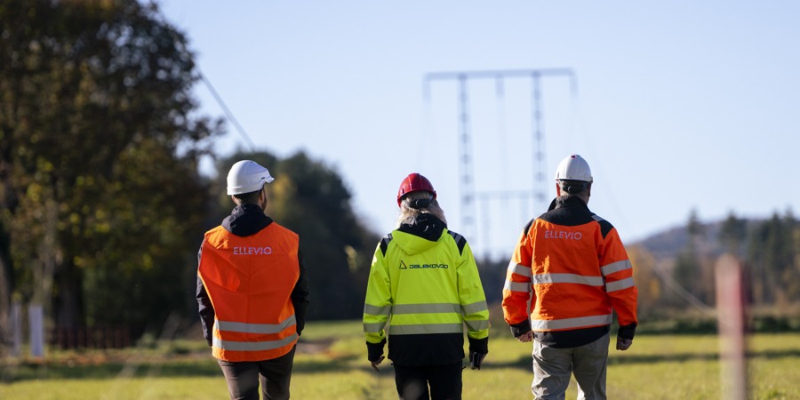 En grupp människor som går över ett grästäckt fält.
