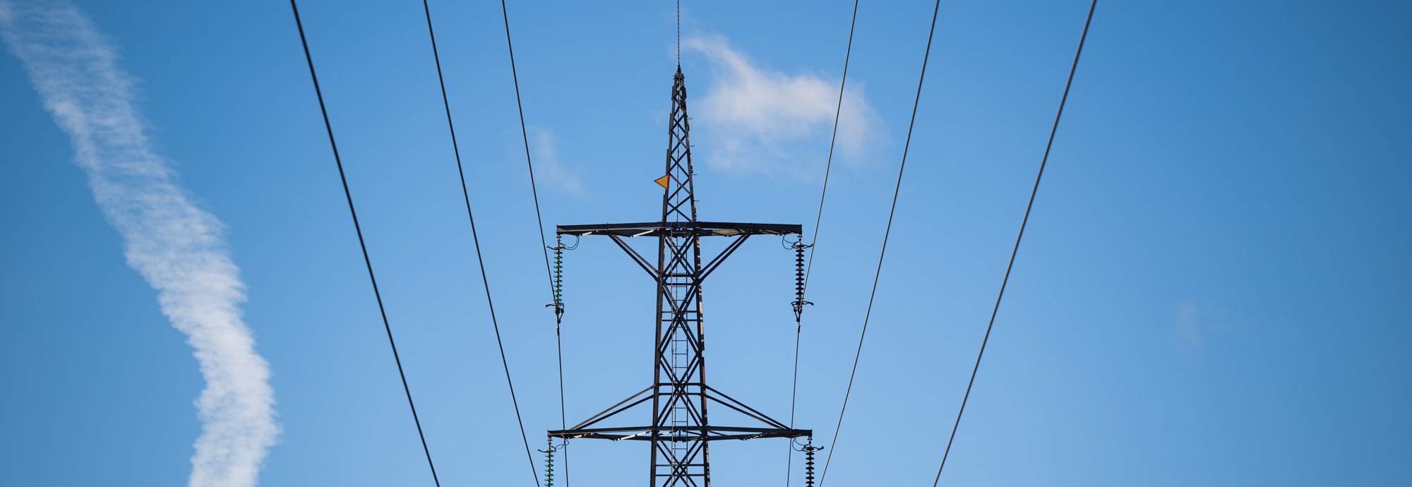 En högspänningsledning mot en blå himmel.