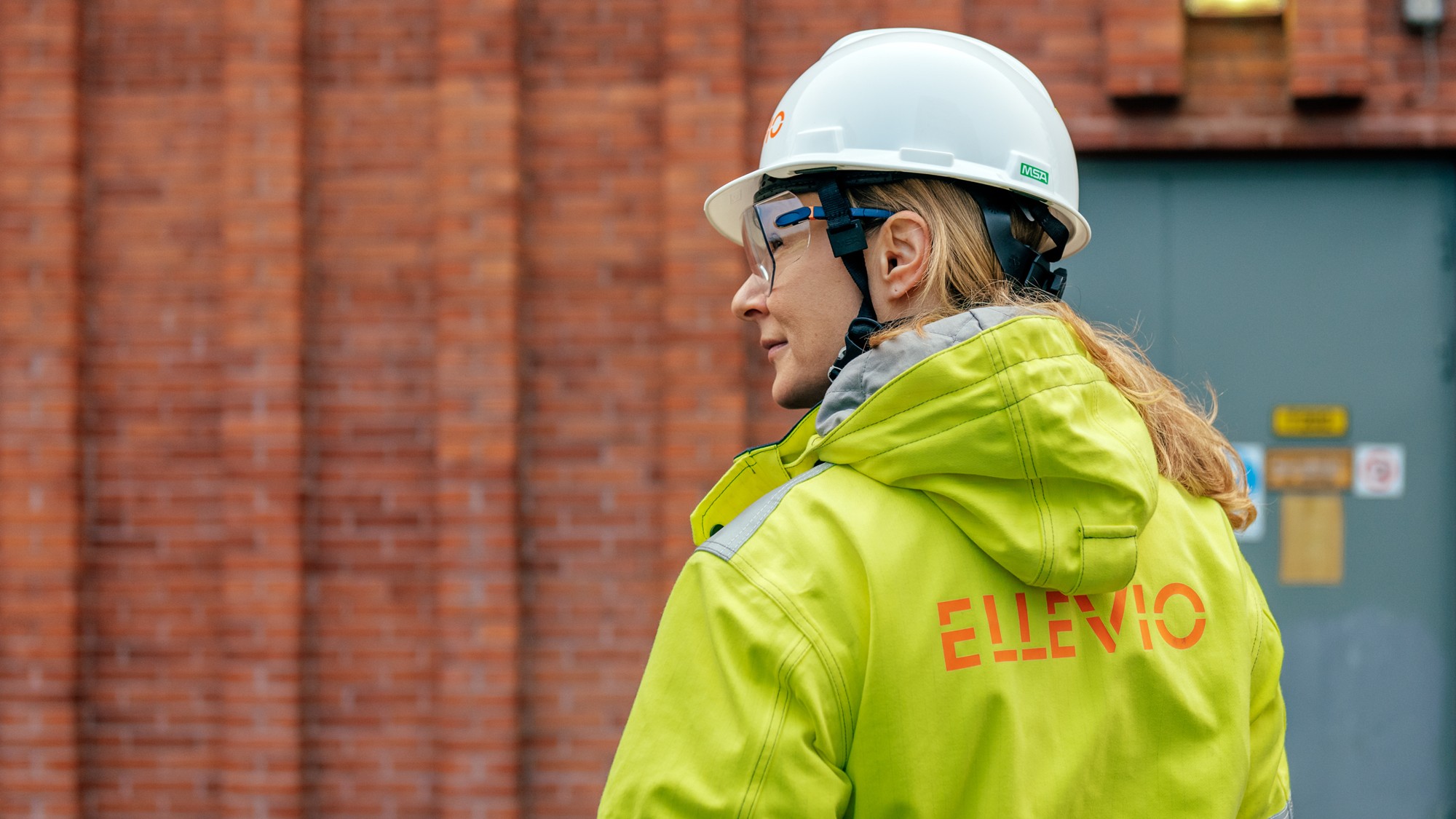 En kvinna iförd skyddsjacka och skyddshjälm.