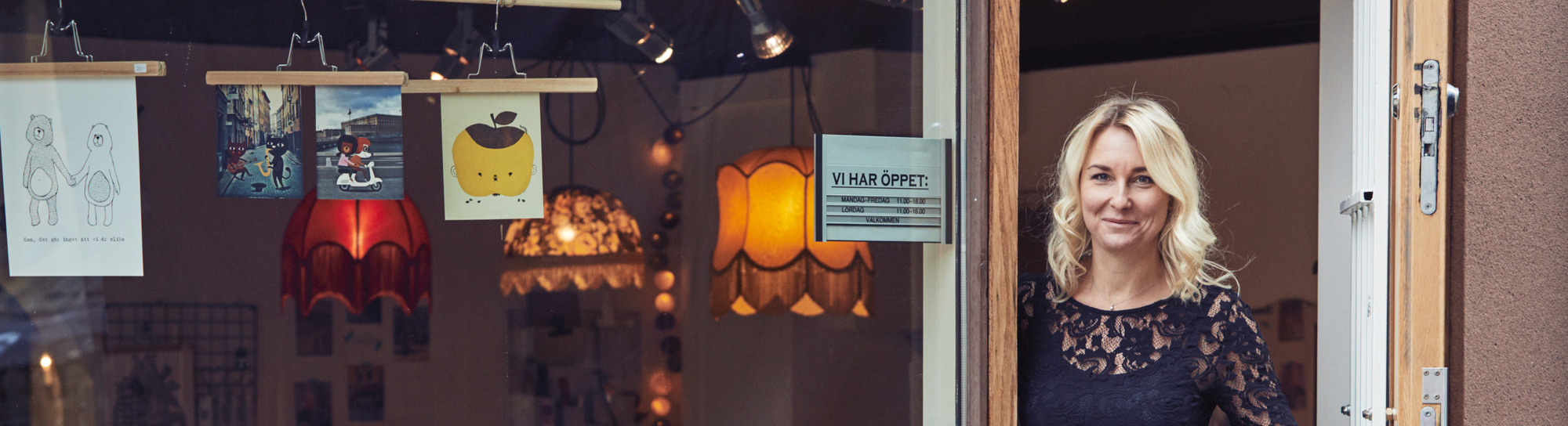 En kvinna som står i dörröppningen till en butik.