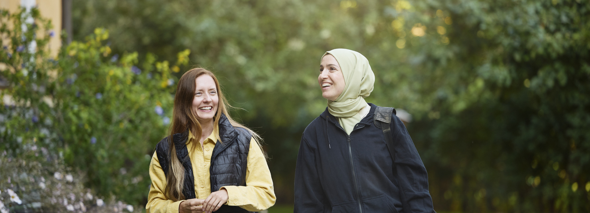 Två kvinnor promenerar på innegård