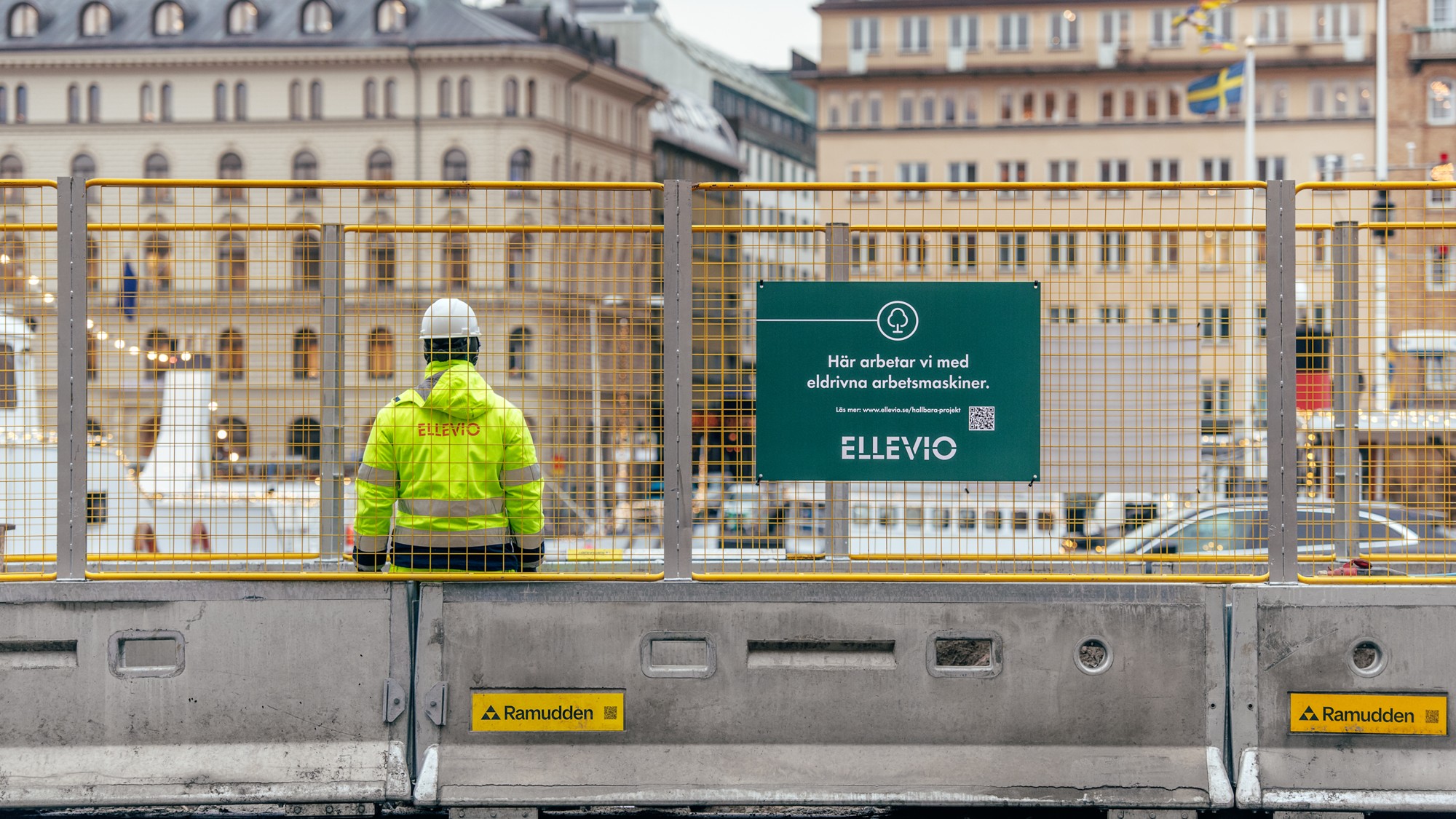 En man i gul jacka står vid ett elnätsarbete.