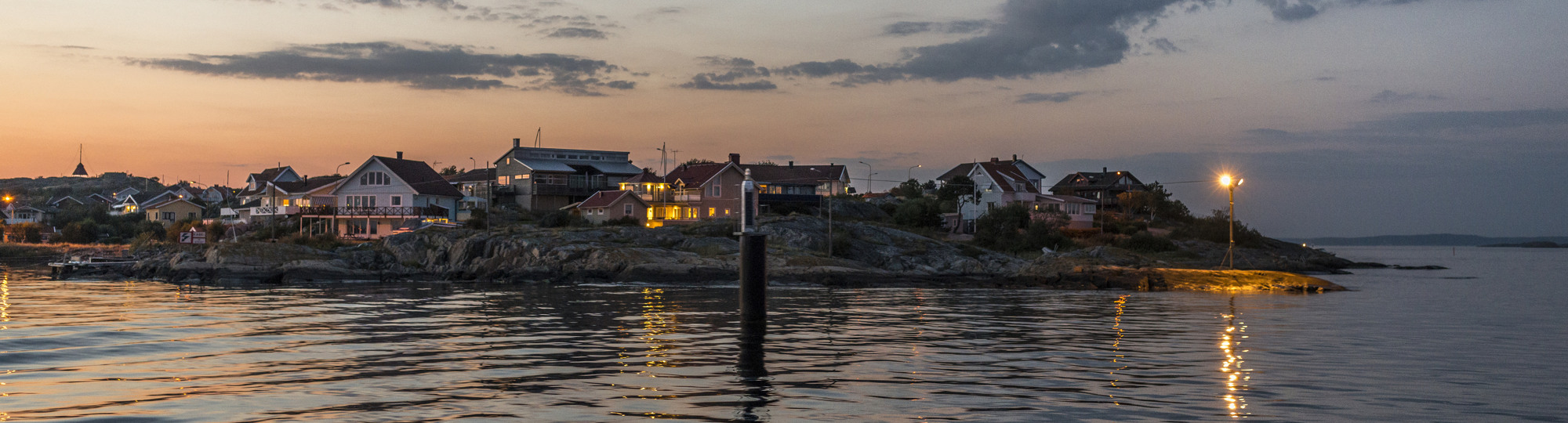 Ett hav med hus på en ö i bakgrunden.