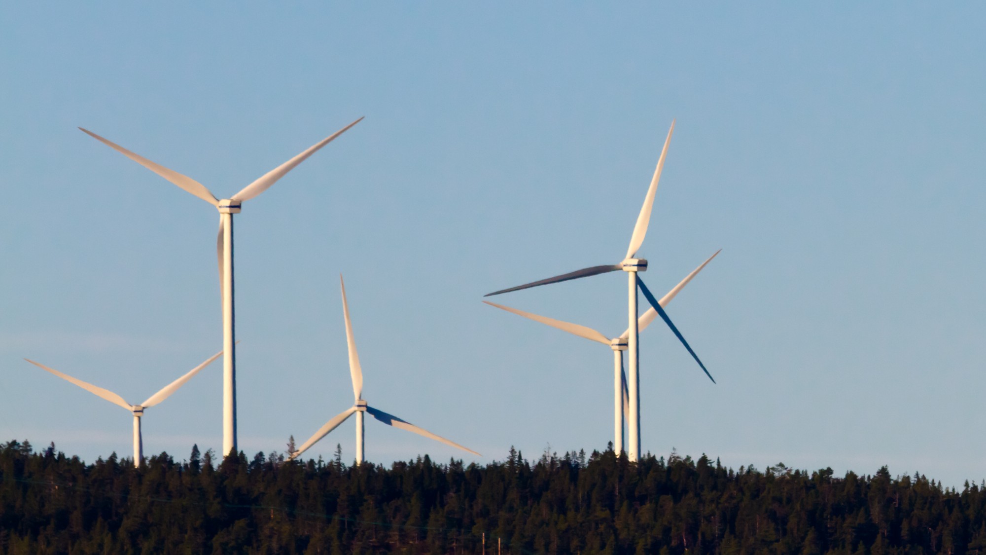 vindkraftverk på toppen av en kulle.
